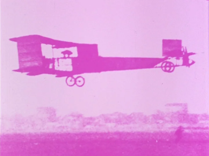 Young Person’s Guide to Cinema (1974) movie still: wide — A vintage biplane silhouette moves across a flat, open landscape. The horizon is low with…