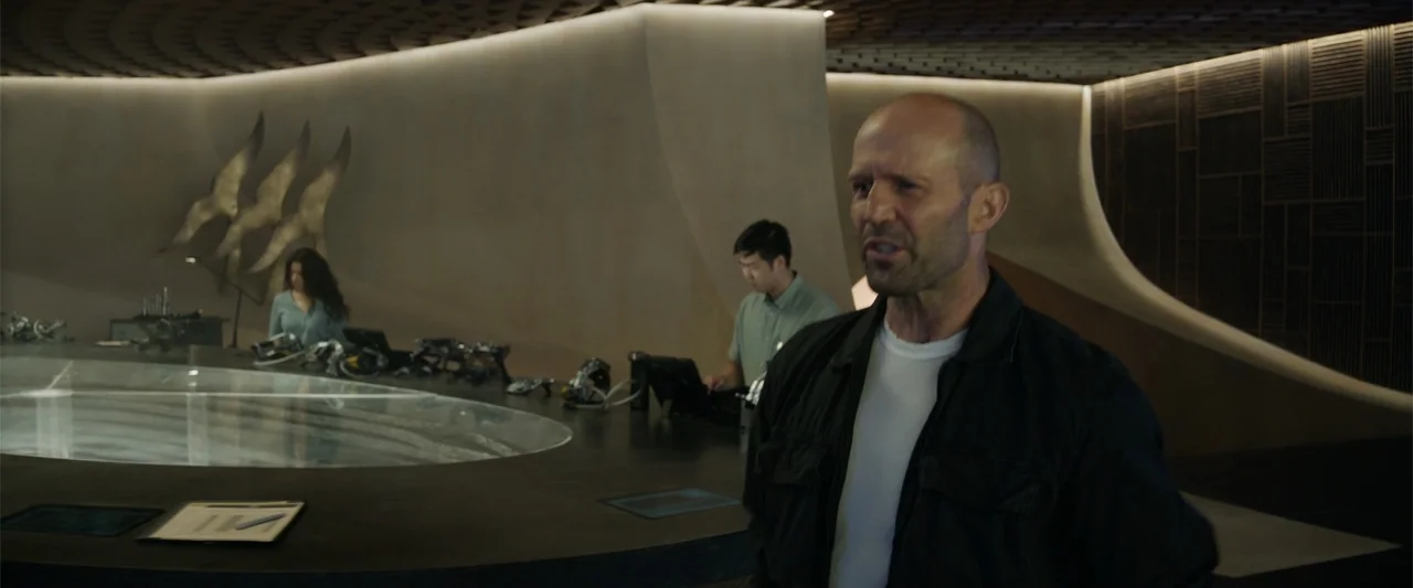 Meg 2: The Trench (2023) movie still: medium — A modern minimalist interior features curved wall surfaces and a large integrated console table. A…
