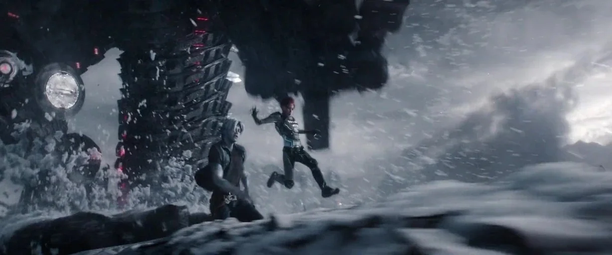 Ready Player One (2018) movie still: wide — A snowy, wind-swept mountain terrain with a massive dark mechanical structure looming overhead. A man…