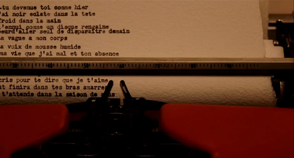 Heartbeats (Les Amours Imaginaires) (2010) movie still: closeup — A close-up view shows a vintage typewriter with a page of French poetry inserted.…