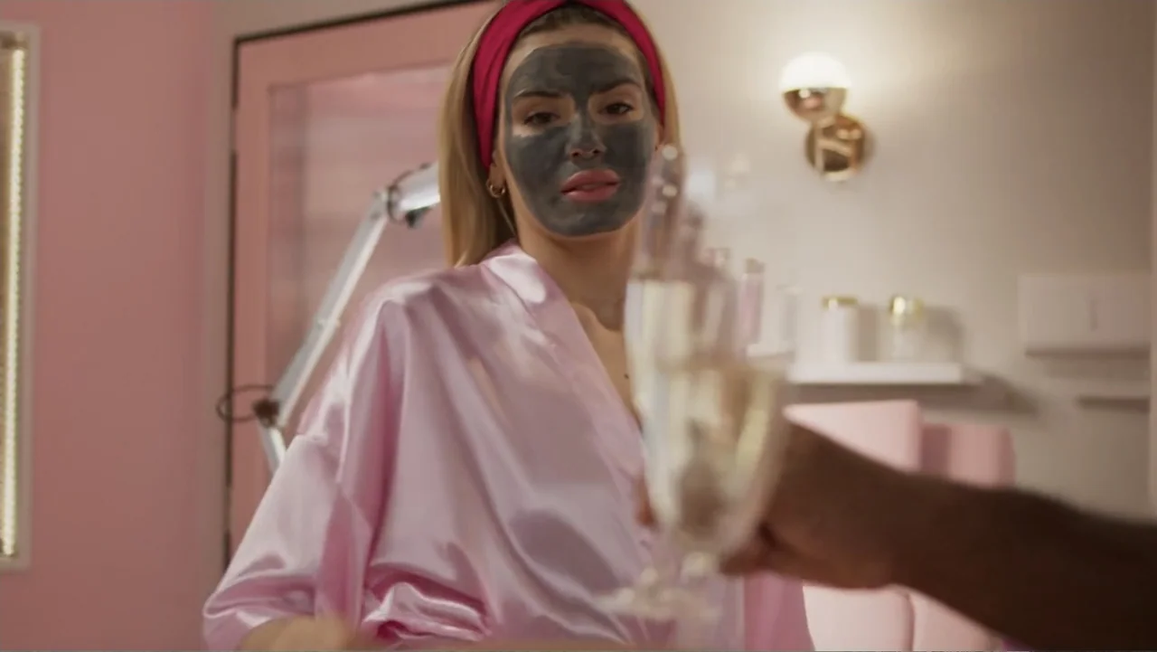 Making of: Scars of Beauty (2025) movie still: medium — A brightly lit room features pink walls and a professional spa treatment setup. A woman…