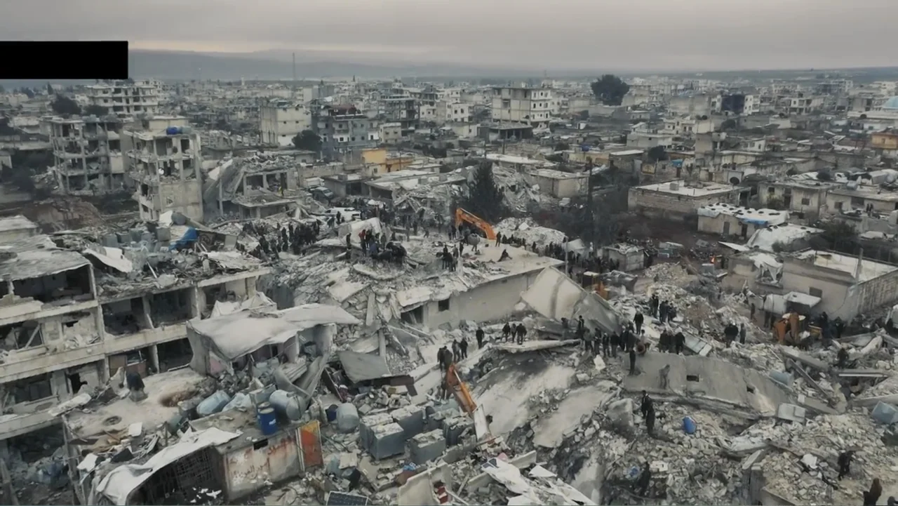 Death Without Mercy (2024) movie still: establishing — A dense urban area features extensive destruction and piles of building debris. Numerous…