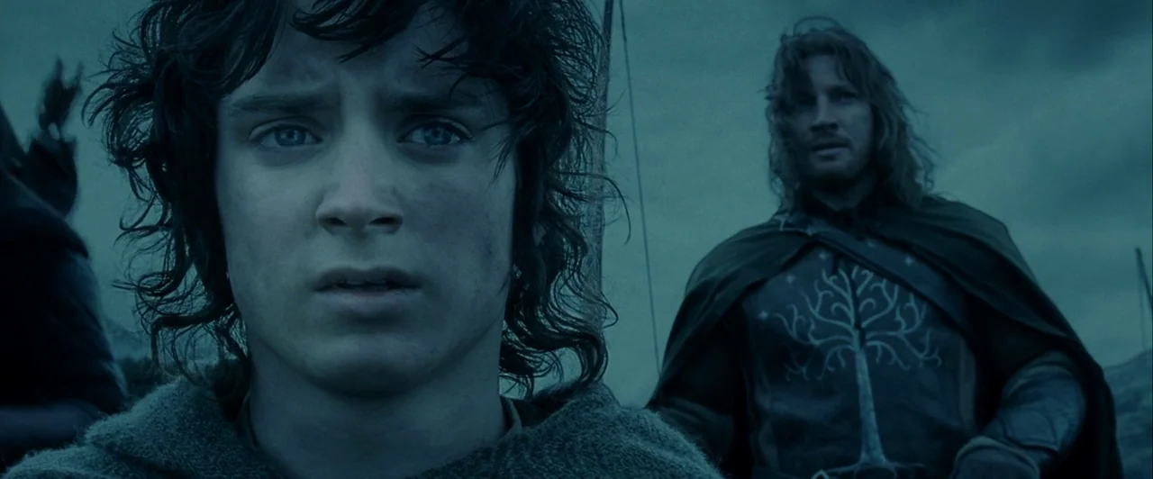 The Lord of The Rings: The Two Towers (2002) movie still: medium — An open landscape under an overcast sky provides the backdrop for two men. The…