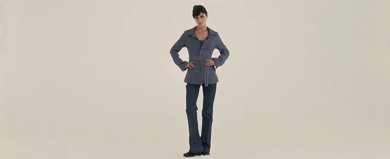 Little Children (2006) movie still: fullbody — A woman stands in the center of a large, seamless, neutral-toned studio space. She keeps her hands on…