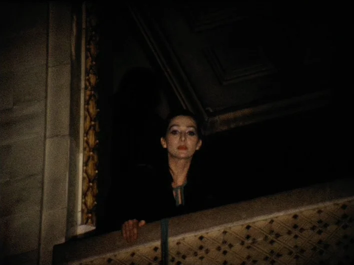 The Death of Maria Malibran (1972) movie still: medium — A dimly lit balcony features dark architectural molding and a textured patterned railing.…