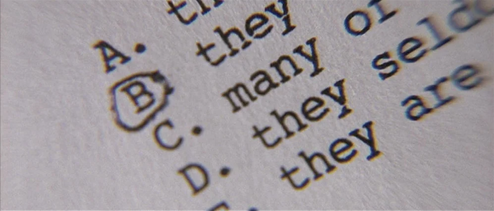 Apt Pupil (1998) movie still: closeup — A close-up view shows a printed multiple choice test on slightly textured white paper. The letter B is…
