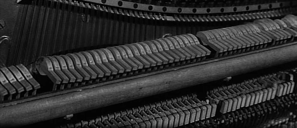 Shoot The Piano Player (Tirez Sur Le Pianiste) (1960) movie still: closeup — The internal mechanism of a grand piano features rows of wooden hammers…