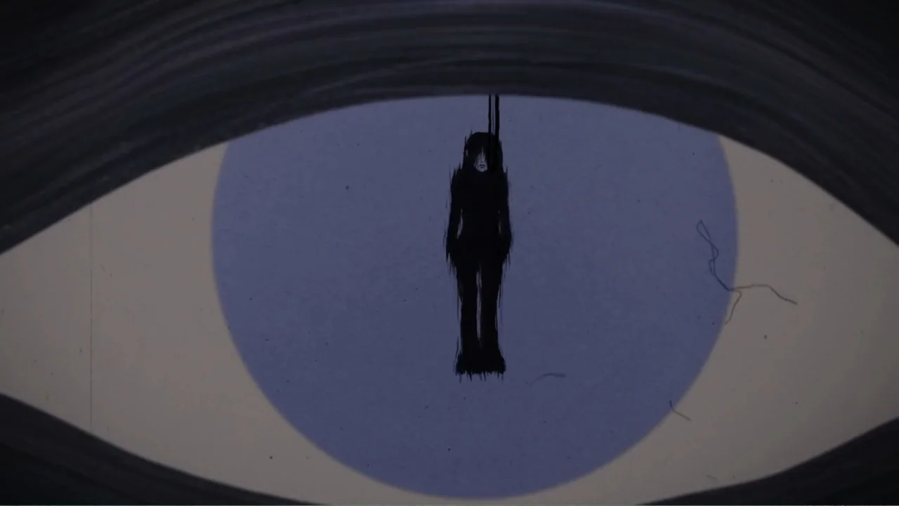 Inland Empire (2006) movie still: closeup — A stylized animation frame shows a dark silhouette suspended within a large eye pupil. The entire scene…