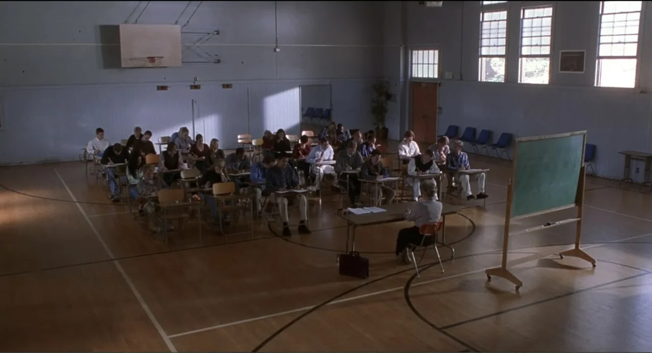 National Lampoon's Van Wilder (2002) movie still: wide — A spacious gymnasium serves as a makeshift classroom with rows of individual school desks.…