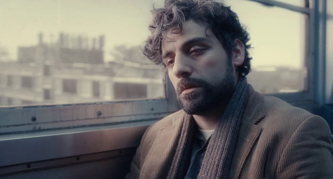Inside Llewyn Davis (2013) movie still: medium — The interior of a subway car features a metal window frame with blurred urban structures. A man…