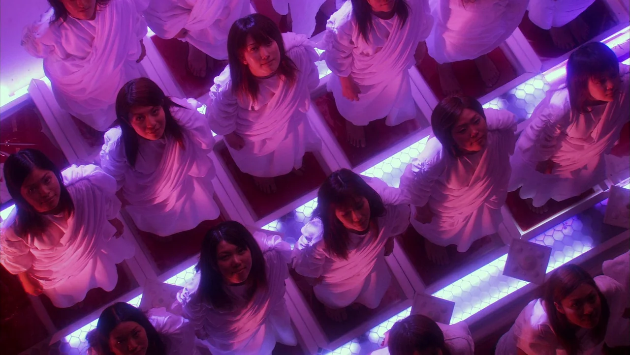 Cutie Honey (2004) movie still: wide — A dark space features a floor composed of illuminated honeycomb-patterned light panels arranged in squares.…