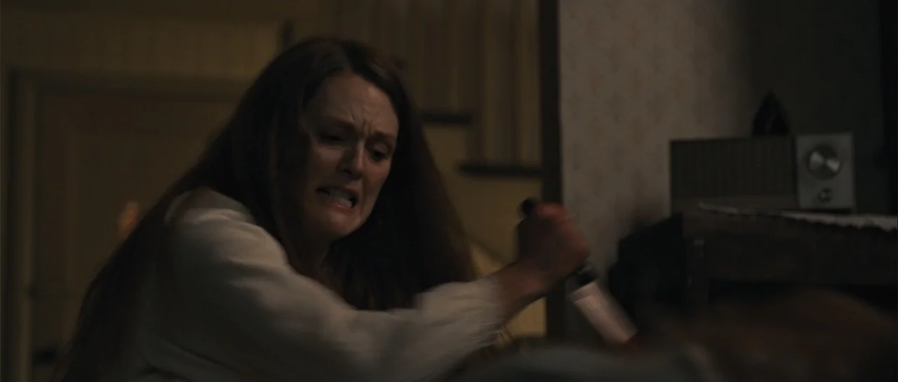 Carrie (2013) movie still: medium — A dimly lit room features patterned wallpaper and a vintage radio on a dresser. A woman wearing a white…