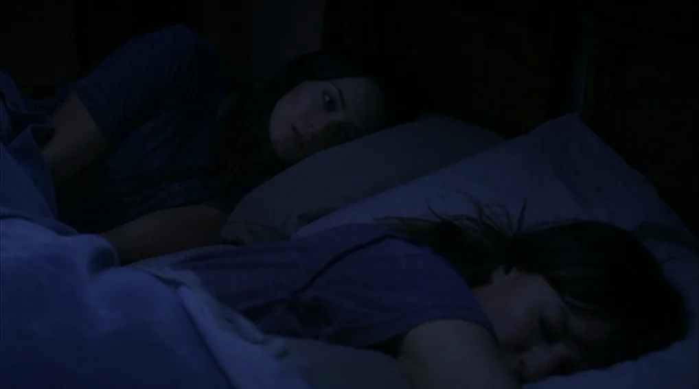 Your Sister’s Sister (2011) movie still: medium — Two women share a dark bed at night under heavy blankets. One woman watches the other who is…