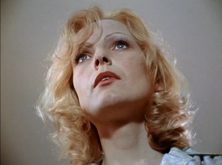 Fear Of Fear (1975) movie still: closeup — A close-up shot of a young woman inside an indoor space. The subject looks upward with her mouth slightly…