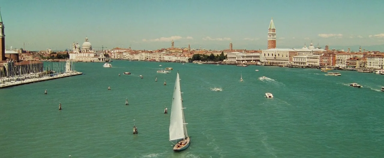 Casino Royale (2006) movie still: establishing — A wide aerial view of the Venetian lagoon with historic city architecture in the distance. A white…
