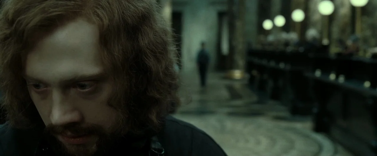Harry Potter & The Deathly Hallows Part 2 (2011) movie still: closeup — A stone bank lobby features rows of high desks and circular pendant lights…