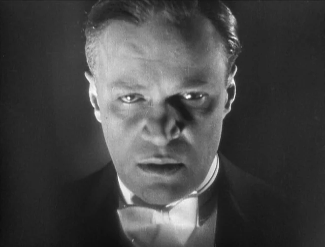 Pandora’s Box (1929) movie still: closeup — A close portrait of a man in formal attire set against a dark void. The subject gazes intensely at the…