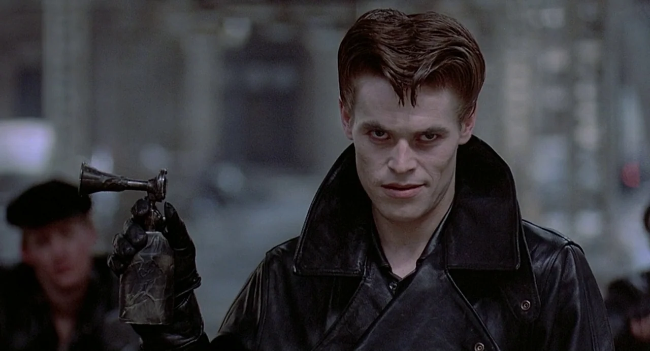 Streets of Fire (1984) movie still: medium — An urban city street at night serves as the backdrop for a stylized encounter. A young man wearing a…
