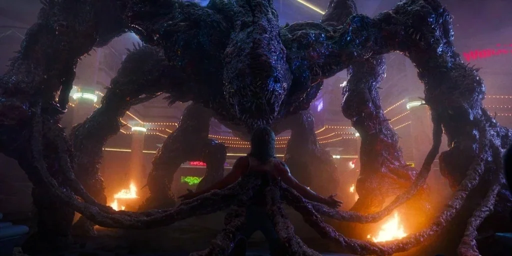Stranger Things (2019) movie still: fullbody — A spacious multi-level shopping mall interior is illuminated by flickering orange firelight and neon…