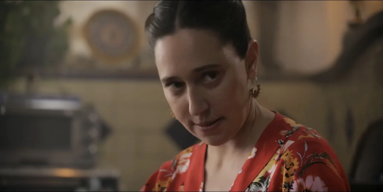 El sabor de la Navidad (2023) movie still: closeup — A woman stands in a kitchen with blurred appliances visible in the background. The subject…