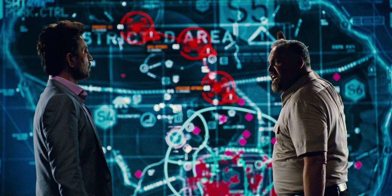 Jurassic World (2015) movie still: medium — A high-tech command center features a massive digital interface wall depicting a restricted map area.…