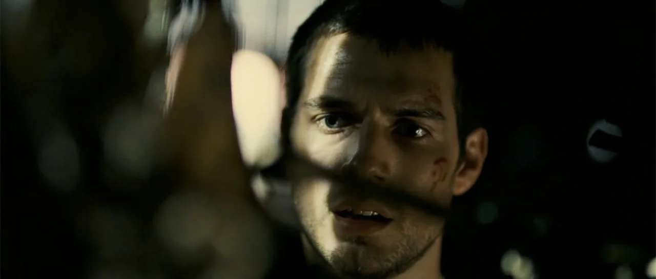 Blood Creek (2009) movie still: closeup — A dark, dimly lit environment features a man in close proximity to the lens. The man has short dark hair,…