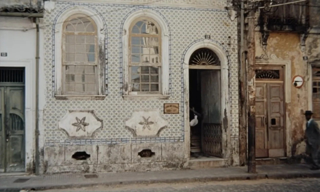 Dona Flor and Her Two Husbands (1976) movie still: fullbody — A street view shows a tiled Portuguese-style building facade with arched windows and…
