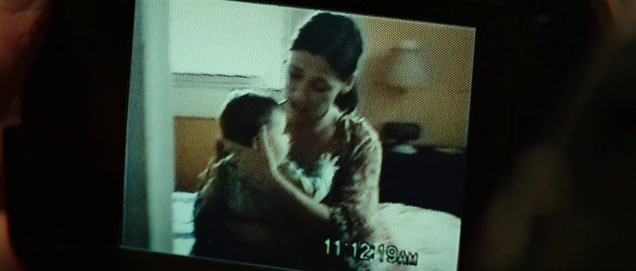 The Boogeyman (2023) movie still: closeup — A low-resolution video recording shows a woman holding an infant in a bedroom. The timestamp on the…