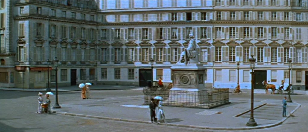 Gigi (1958) movie still: wide — An open plaza is surrounded by symmetrical stone buildings with numerous windows and shutters. A central stone…