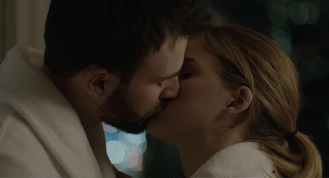 Before We Go (2014) movie still: closeup — A close view shows two people in white bathrobes inside a dimly lit space. The man and woman embrace and…