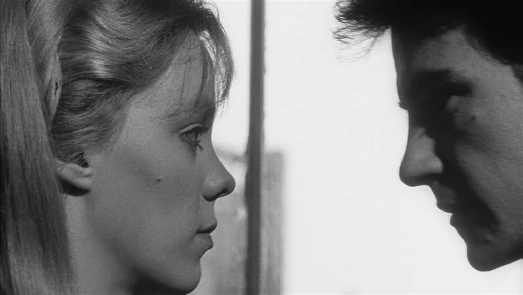 Who’s That Knocking At My Door (1967) movie still: closeup — Two individuals stand in profile against an indistinct, bright urban background. They…
