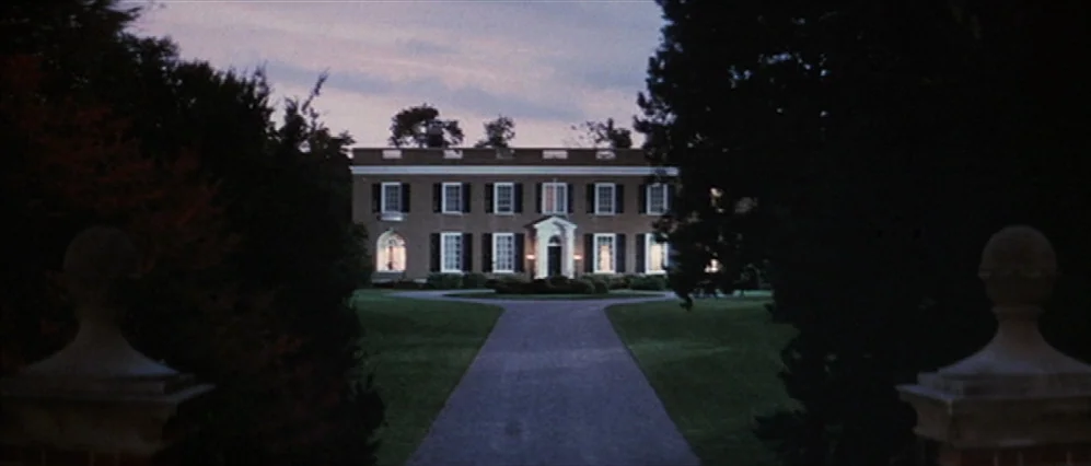 The Fortune (1975) movie still: establishing — A large brick two-story Georgian mansion sits at the end of a long driveway. Mature trees frame the…