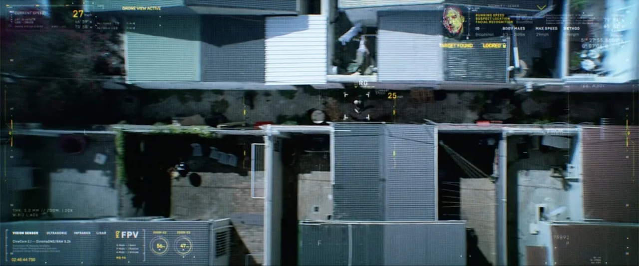 Bloodshot (2020) movie still: establishing — A top-down view shows a narrow residential alleyway bordered by multiple suburban houses. A single…