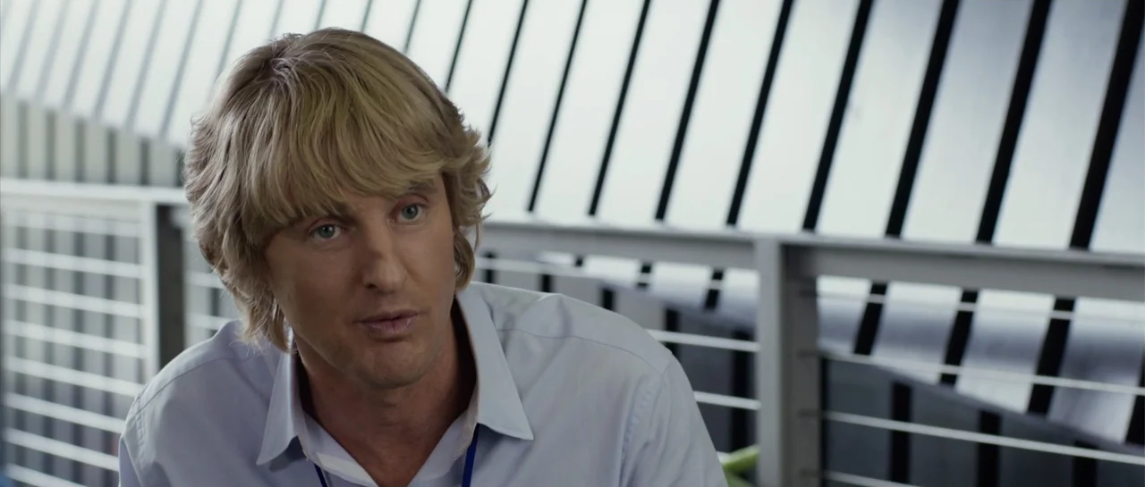 The Internship (2013) movie still: medium — An interior office space with a window featuring black vertical slats in the background. A man wearing a…