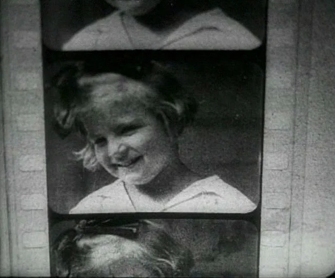 Man with a Movie Camera (1929) movie still: closeup — A 16mm film strip showing a series of individual frames of a child. The central frame captures…