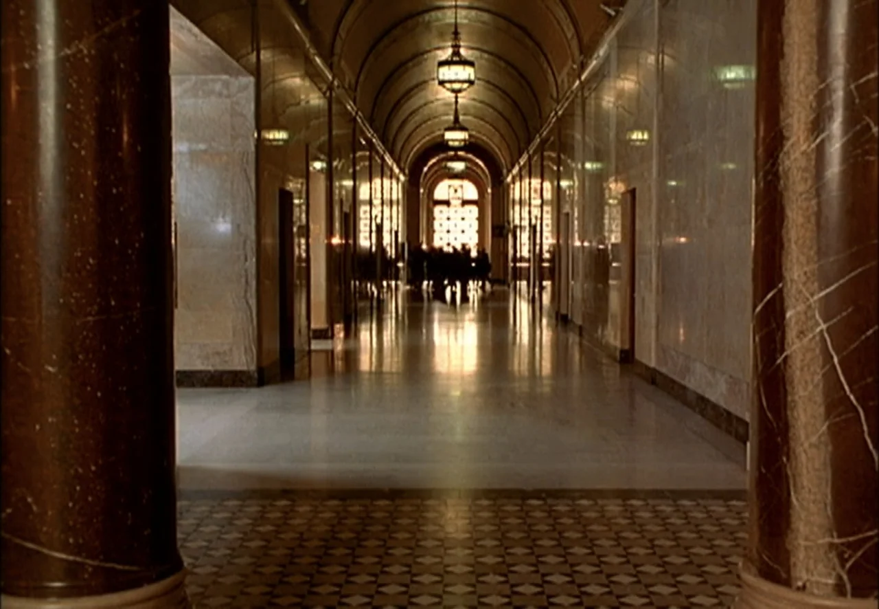 The Pentagon Wars (1998) movie still: establishing — A long, symmetrical marble lobby with dark polished columns and a checkered floor pattern. A…