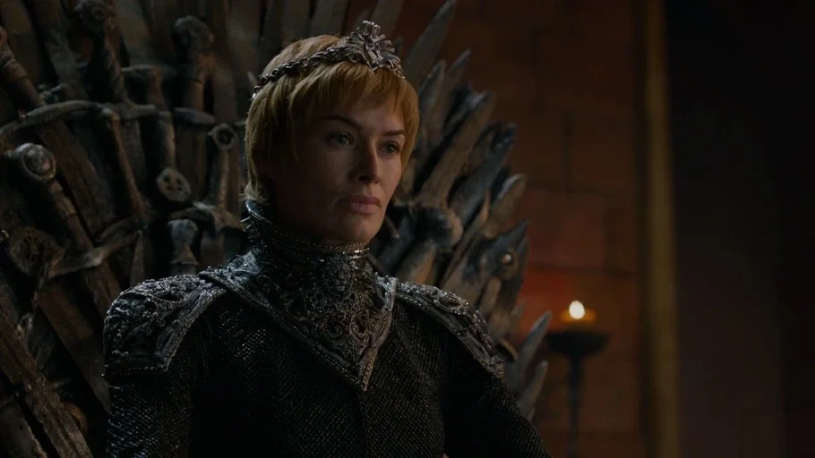 Game of Thrones (2017) movie still: medium — A dark stone room contains a massive chair constructed from numerous welded swords. A woman wearing a…