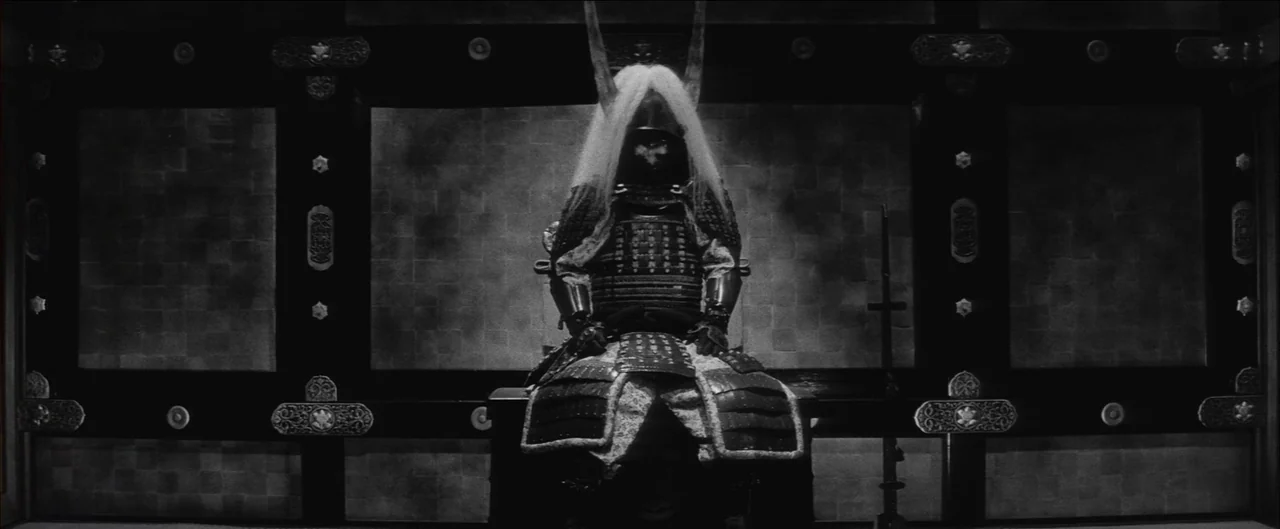 Harakiri (1962) movie still: fullbody — A dark, formal interior space features paneled walls with metallic circular decorative accents. A figure in…