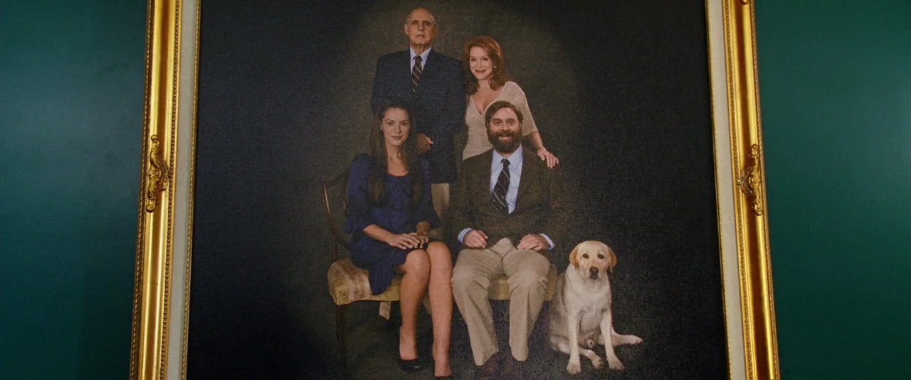 The Hangover Part III (2013) movie still: medium — A formal family portrait hangs on a dark teal wall in a gold frame. Four adults and a golden…