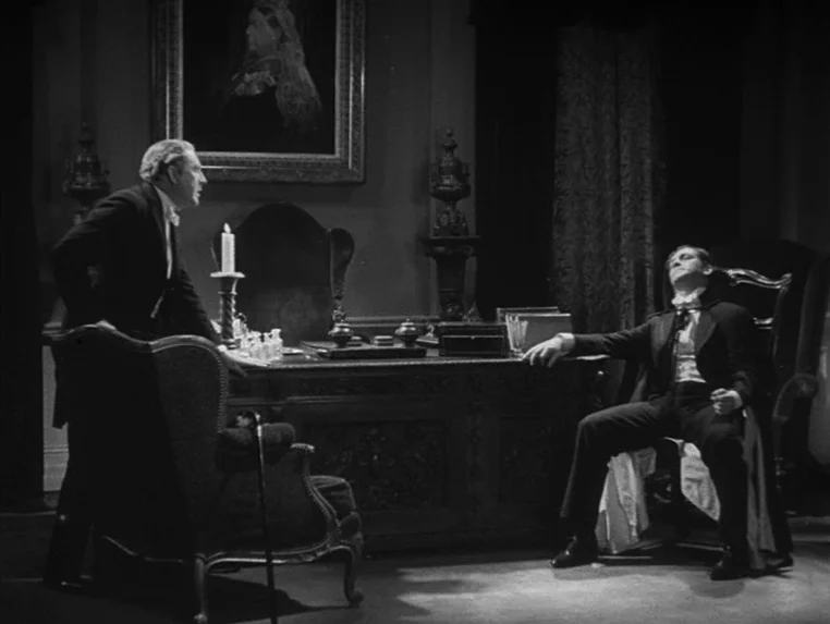 Dr. Jekyll and Mr. Hyde (1931) movie still: wide — A dark Victorian-era study features a heavy wooden desk and an ornate framed portrait. One man…