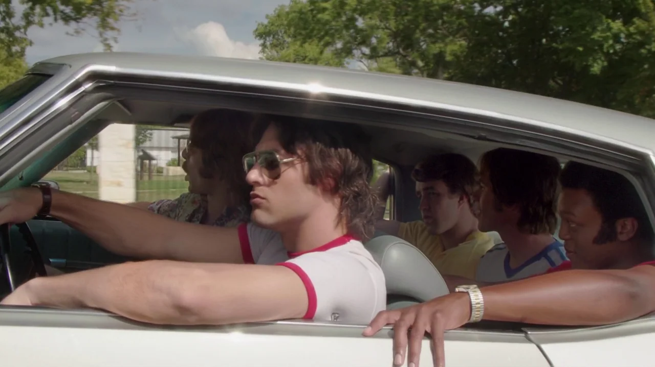Everybody Wants Some!! (2016) movie still: medium — A group of five young men travel together inside a 1970s sedan vehicle. They are positioned…