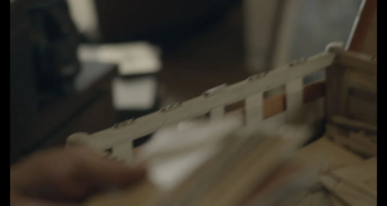 Living With Lincoln (2015) movie still: closeup — An interior space contains a white wooden crate filled with documents and papers. A hand reaches…