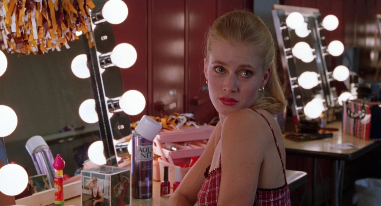 Drop Dead Gorgeous (1999) movie still: medium — A dressing room features rows of lighted mirrors and maroon locker cabinets in the background. A…