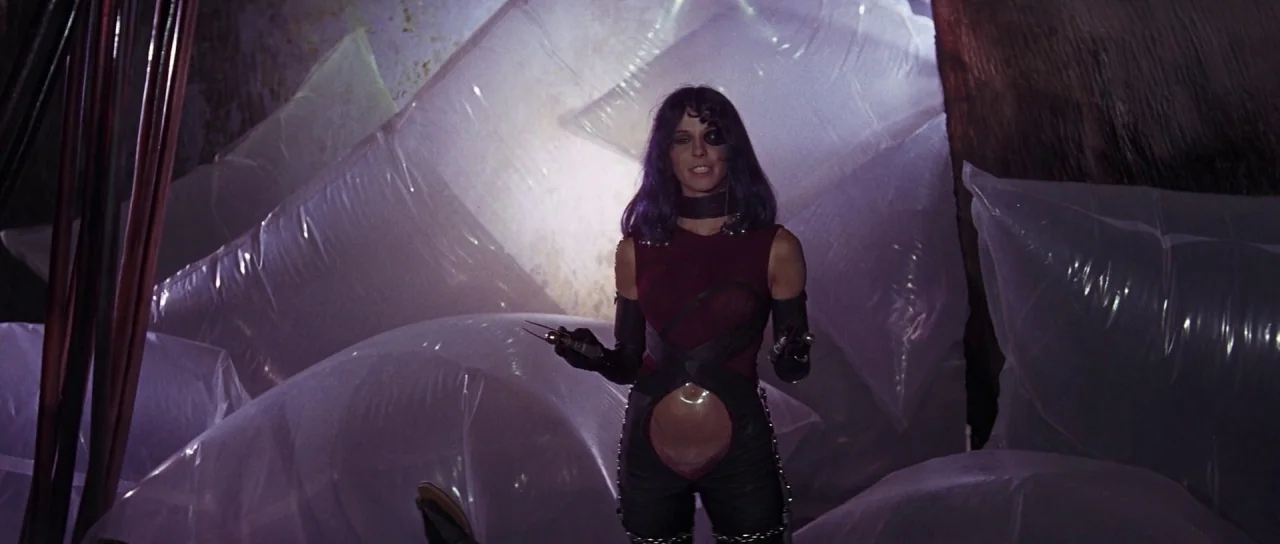 Barbarella (1968) movie still: medium — A dark industrial space is filled with large, transparent plastic-filled bags. A woman wearing an eye patch…
