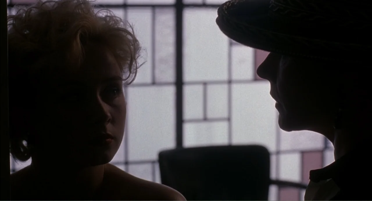 Wild Orchid II: Two Shades of Blue (1991) movie still: medium — An interior space features a large window with a dark pane grid. Two women stand…