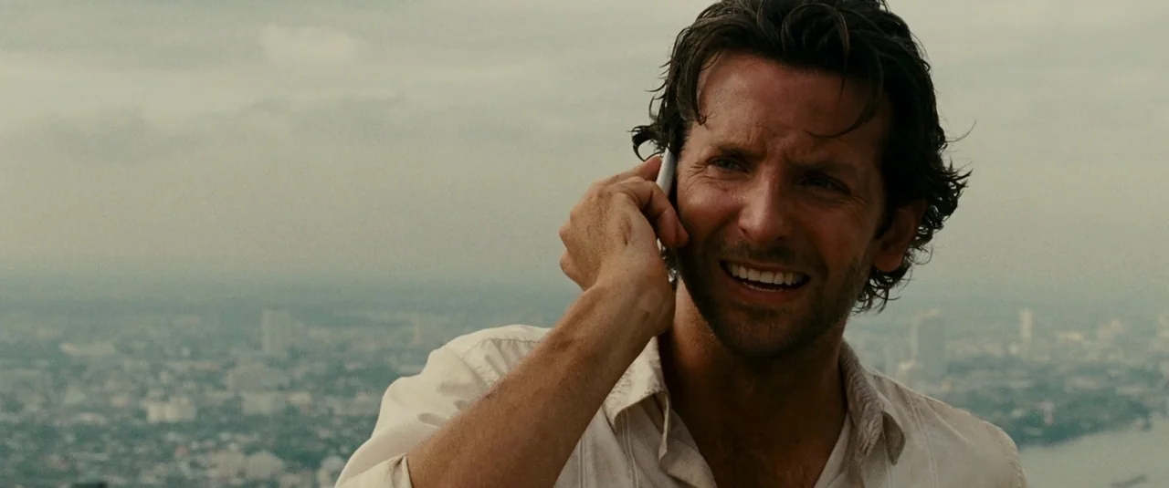 The Hangover Part II (2011) movie still: medium — An expansive cityscape is visible in the soft-focus background behind the man. A man wearing a…
