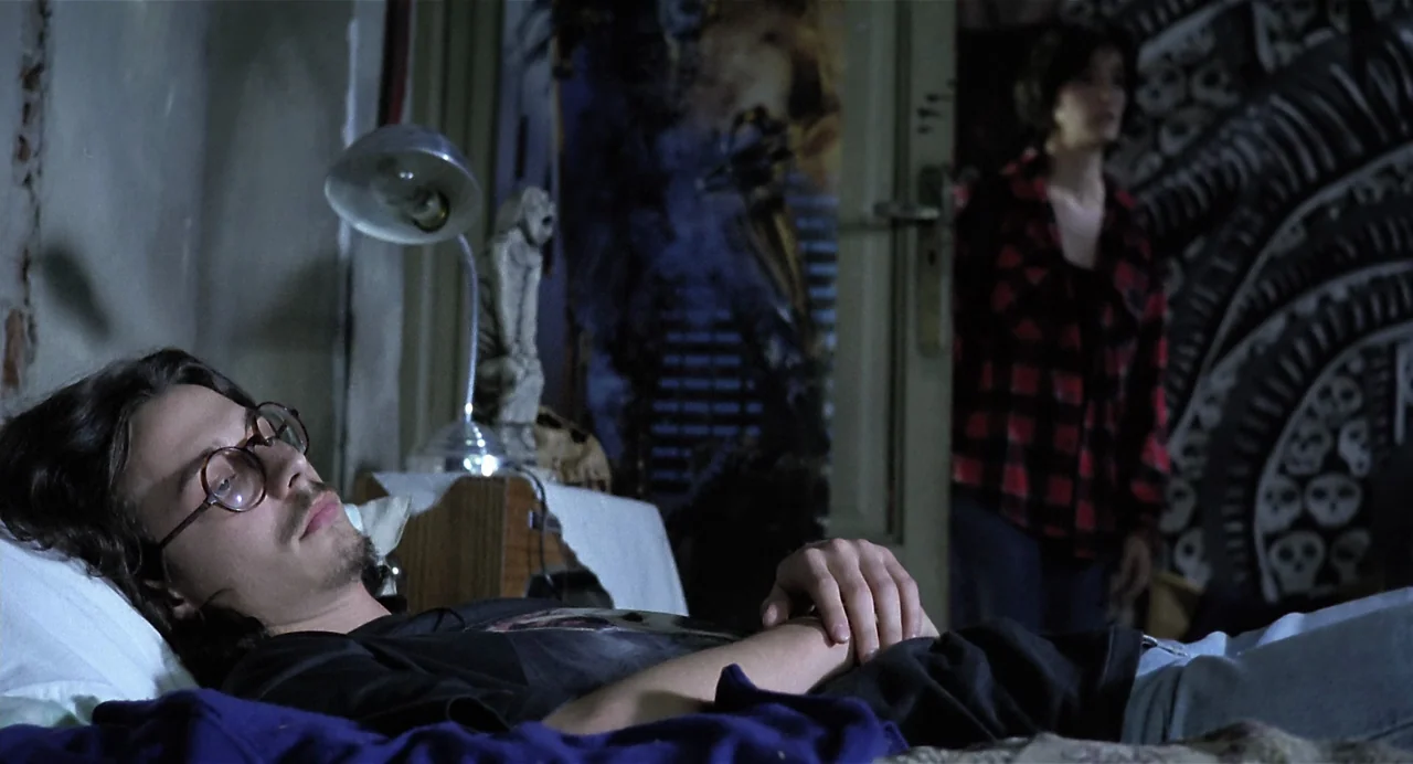 Thesis (1996) movie still: medium — A dimly lit room features a man lying on a bed with a lamp.