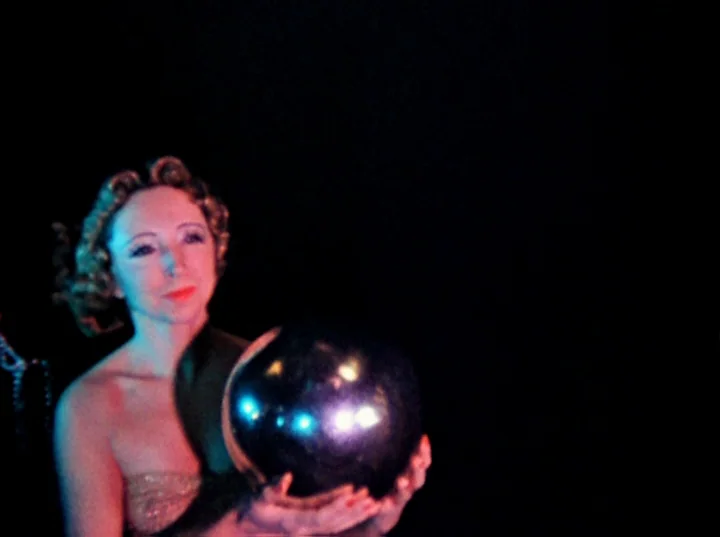 Inauguration of the Pleasure Dome (1954) movie still: medium — A woman stands in complete darkness against an undiscernible black backdrop. She…