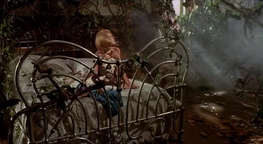 Lisa and The Devil (1973) movie still: medium — A dark bedroom is overgrown with tangled vines and filled with thick haze. A young girl sits on a…
