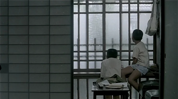 A Time To Love and A Time To Die (1985) movie still: medium — A quiet indoor space features a wall of light-colored tiles beside a large window. Two…